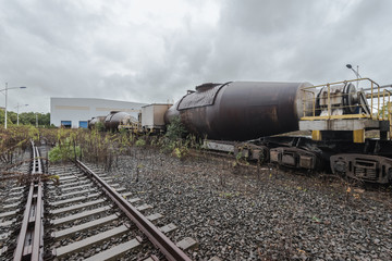 Fototapeta na wymiar cargo trains stopped on old railroad in abandoned industrial site