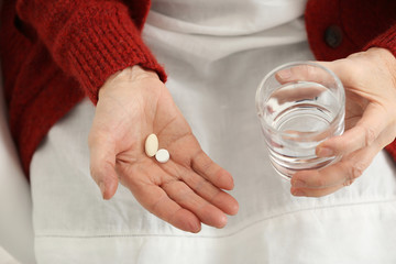 Elderly woman taking pills, closeup
