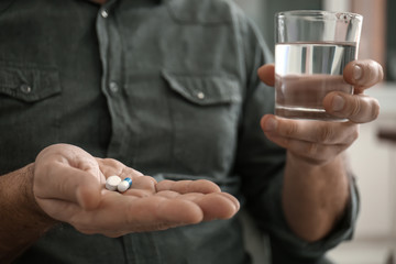 Mature man taking pills, closeup