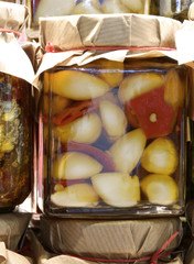 garlic cloves with red peppers in oil on sale in the stall