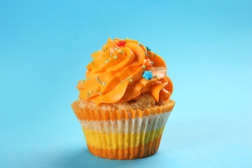 Tasty cupcake on color background