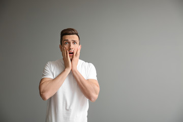 Stressed young man on grey background