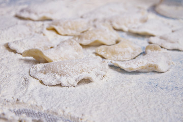 Fototapeta na wymiar Dumplings with curd on table sprinkled with flour