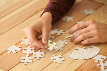 Woman assembling puzzle on table