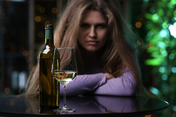 Depressed woman drinking alcohol in bar