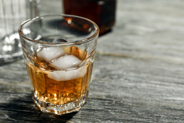 Glass of whiskey on wooden table