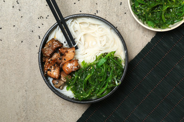 Tasty Chinese soup in bowl on grey table