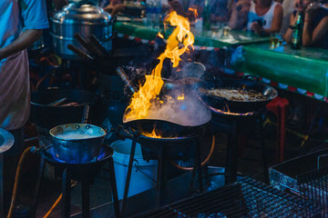 Close up movement hand the chef cooking Pad Thai in a pan at street chinatown or Yaowarat Road in Bangkok, Thailand, Select focus.