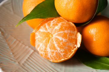 Tasty tasty juicy tangerines on plate, closeup