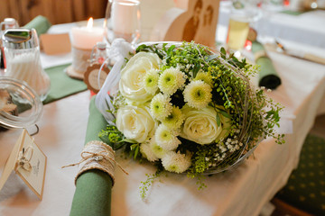 Schöner gelber Brautstrauß liegt dekorativ auf einem Tisch bei einer Hochzeit