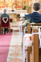 Mittelgang einer Kirche mit Blumen geschmückte Kirchenbänke während einer Hochzeit