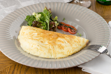 omelette and vegetables on grey plate on wooden table