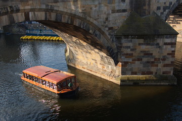 Fototapeta na wymiar Excursion boat under the Charles Bridge in Prague
