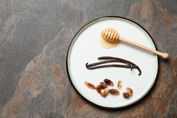Fototapeta premium Plate with aromatic vanilla sticks, honey and sugar on grunge background