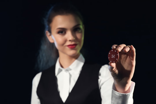 Beautiful female banker with chip on dark background