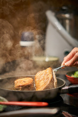 bratendes Fleisch wird gewendet