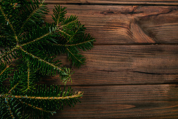 Background texture of a fir tree branches on the wooden table. Christmas card template.