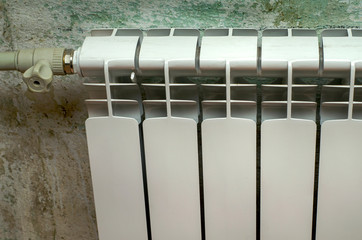 White radiator heating on a green wall background