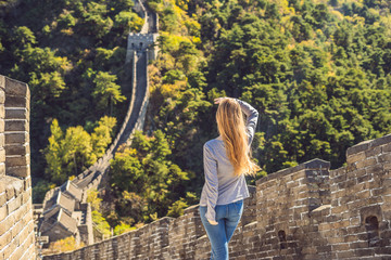 Happy cheerful joyful tourist woman at Great Wall of China having fun on travel smiling laughing and dancing during vacation trip in Asia. Girl visiting and sightseeing Chinese destination