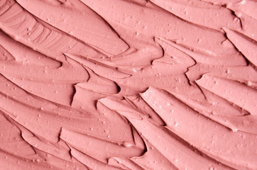 Soft pink cosmetic clay (facial mask, cream) texture close up, selective focus. Abstract background with brush strokes.