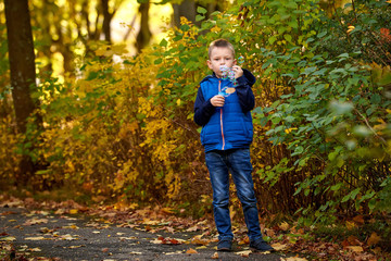 Little boy playing with soap bubbles, outdoor