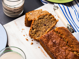 Banana bread loaf sliced on wooden board