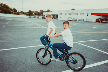 Brothers making tricks riding on one bike together