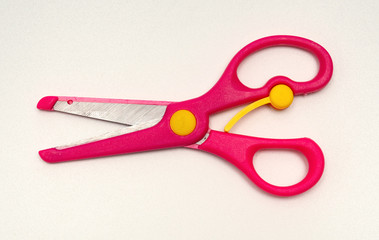 red handcraft scissors for children on a white background