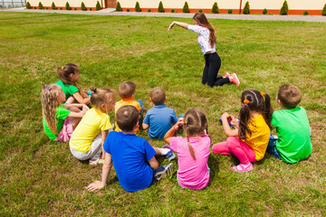 Back view of children spending time outside and playing charades
