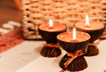 Burning spa aroma candles in coconut shell, cozy home interior 