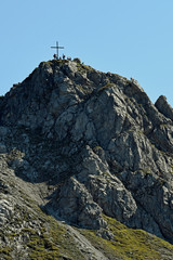 Fototapeta premium personen am gipfelkreuz der kanzelwand im kleinwalsertal