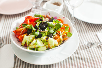 Salad with fresh vegetables, olives and pumpkin sprouts