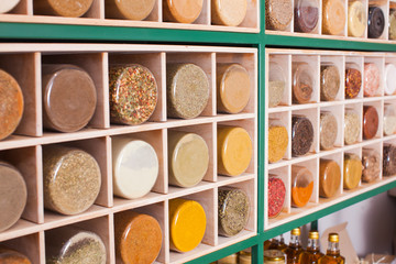 Close view of spices in glass jars on wooden shelf