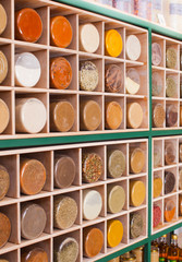 Wooden rack with cells filled with spices in jars