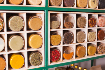 Collection of glass jars with spices on wooden stand
