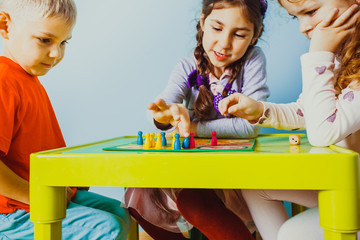 Close view of children faces around table with board game