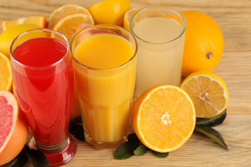 Citrus juices. orange, lemon and grapefruit juice with fresh fruits on a natural wooden background.