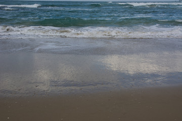 Waves crashing on shoreline with moody dramatic sky