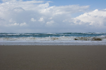 Waves crashing on shoreline with moody dramatic sky
