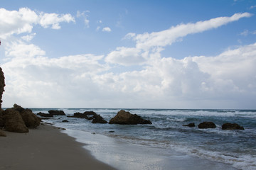 Fototapeta na wymiar Waves crashing on shoreline with moody dramatic sky