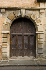Fototapeta na wymiar An ancient studded wood entrance door on a street in Cirencester, Gloucestershire, UK