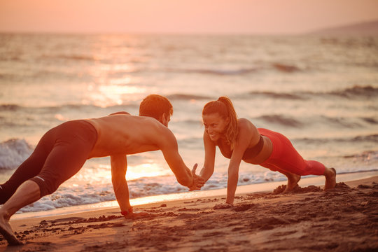 Couple Doing Pushups On Beach