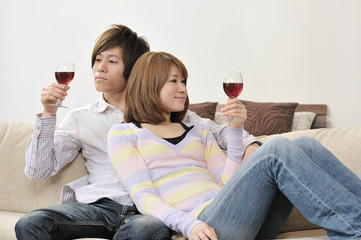ソファに座ってワインを飲むカップル