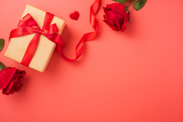 Gift box with red ribbon and rose in trendy colour of 2019 living coral, concept of Valentine's, anniversary, mother's day, copy space, top view.