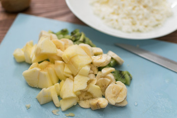 Sliced banana and kiwi on a cutting board. Cooking fruit salad.