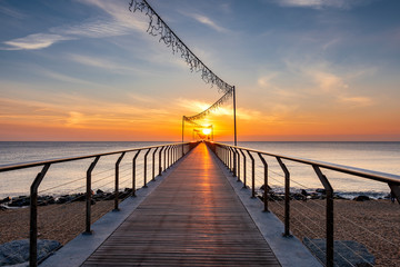 Bridge on the beach at sunrise