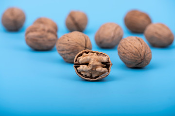 Walnuts on blue surface, half walnut with nutshell