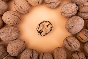 Cracked half walnut on yellow background, walnut top view photo