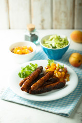 Fried sausages with fruit salsa