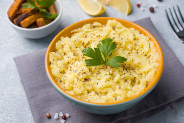 Mashed potatoes with herbs, croutons and lemon in a plate on napkins.